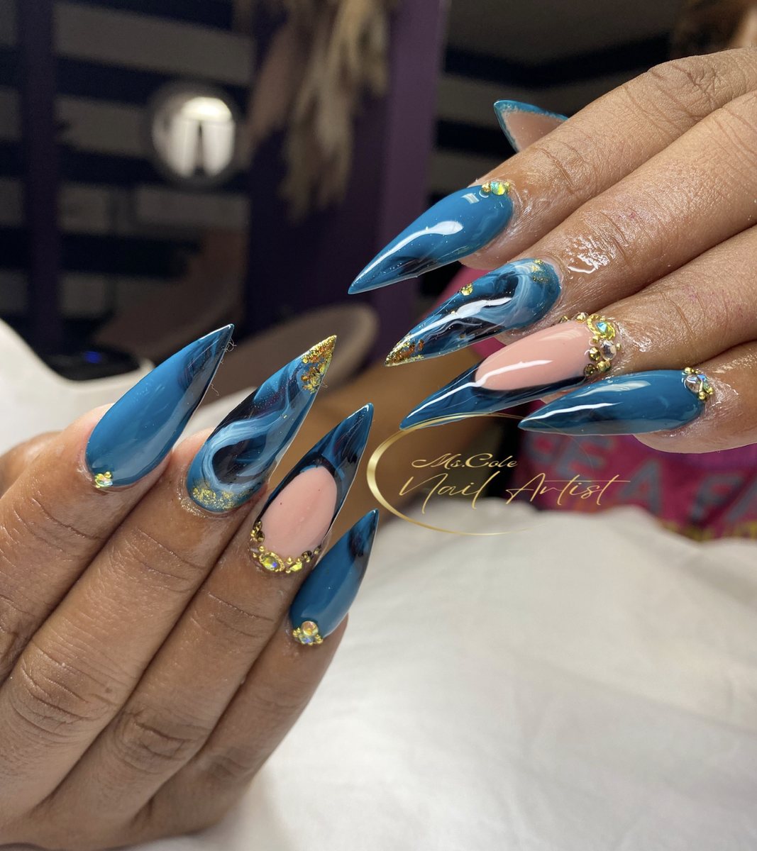 Blue chrome stiletto nails with gold gems
